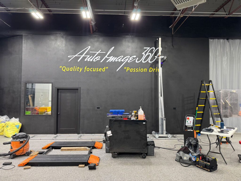 Large wall mural printed by ArtWall Pro at Auto Image 360, featuring the company’s logo and slogan on a black background.