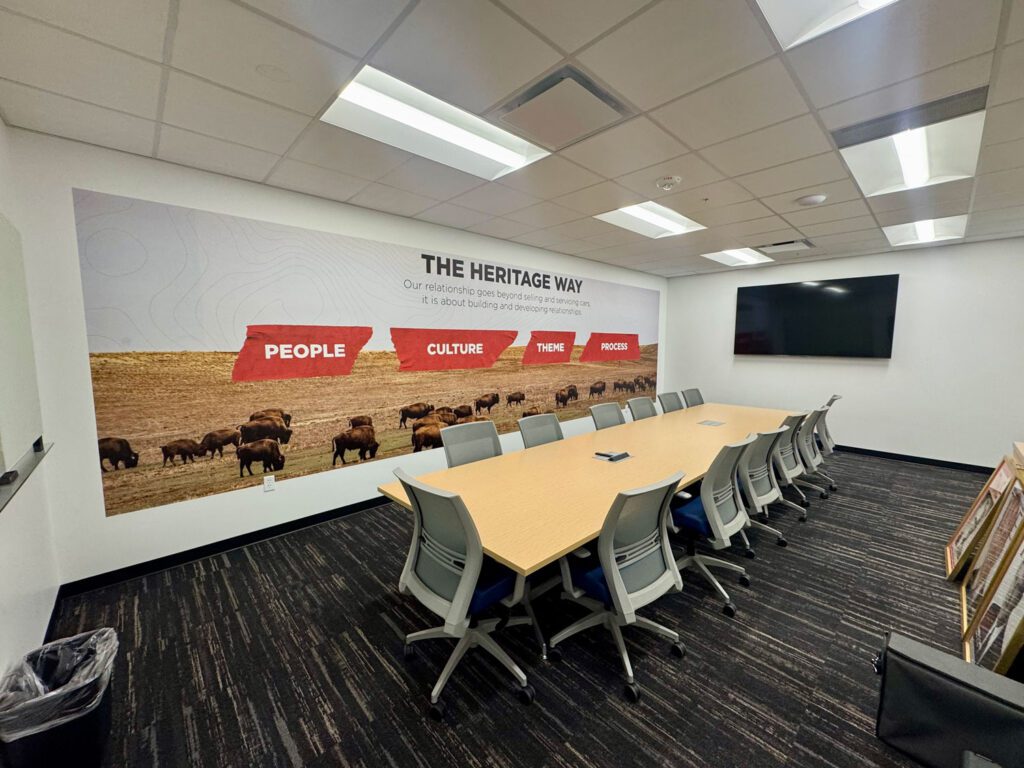 Custom office wall mural printed directly onto drywall in a corporate conference room, featuring branded company values for Heritage Auto — large-format wall printing by ArtWall Pro in Denver.