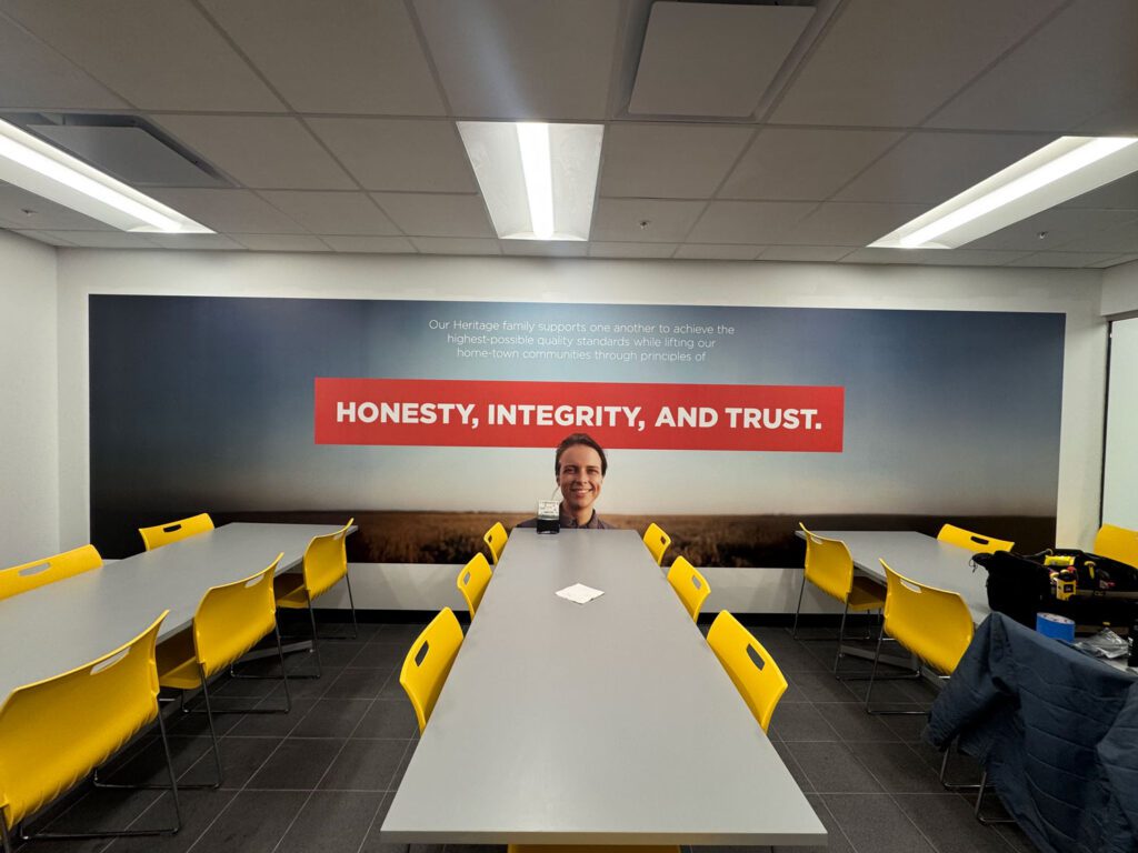 Corporate breakroom with a modern wall mural reading ‘Honesty, Integrity, and Trust,’ demonstrating how office wall art can communicate company values and enhance workplace culture.