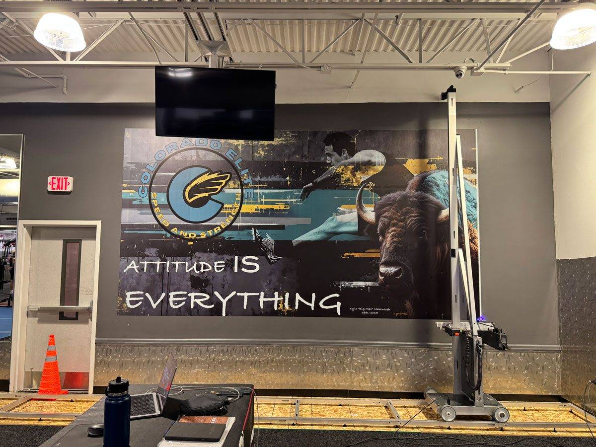 Canvas wall art decor covering a commercial office wall, featuring a modern-mural-style illustration of mountains and cityscape in muted tones